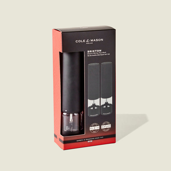 Cole & Mason Brixton Electric Mill Matt Black GS in black packaging with product images and brand information displayed on the front, featuring a durable ceramic grinder for long-lasting performance, all set against a light beige background.