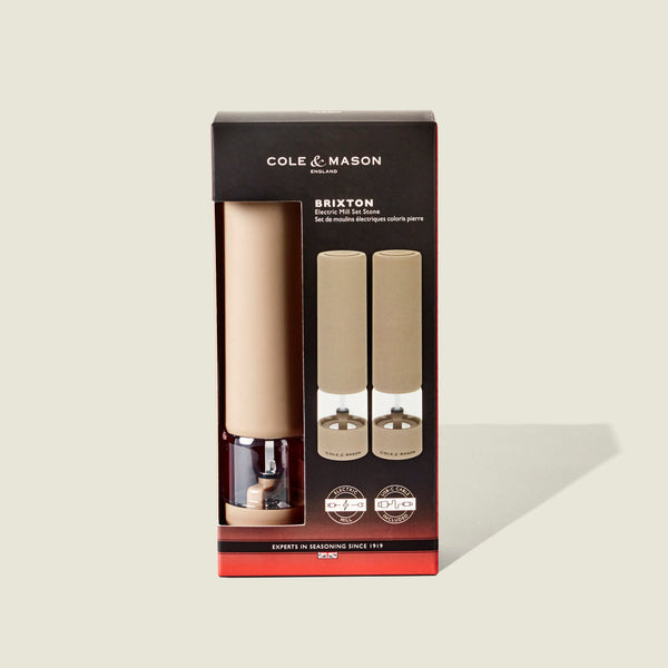 Cole & Mason Brixton Electric Mill Stone GS in beige and clear acrylic, featuring an adjustable grind for customizable seasoning. Presented in a black box with red accents and a clear window showcasing the mills inside.