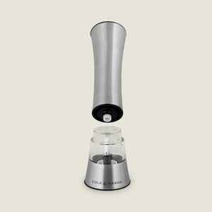 The Cole & Mason Burford Electronic Single Mill is a stainless steel pepper grinder with one-handed operation, adjustable grind settings, and a visible electronic mechanism when the top is lifted. The clear chamber is labeled “Cole & Mason.”.
