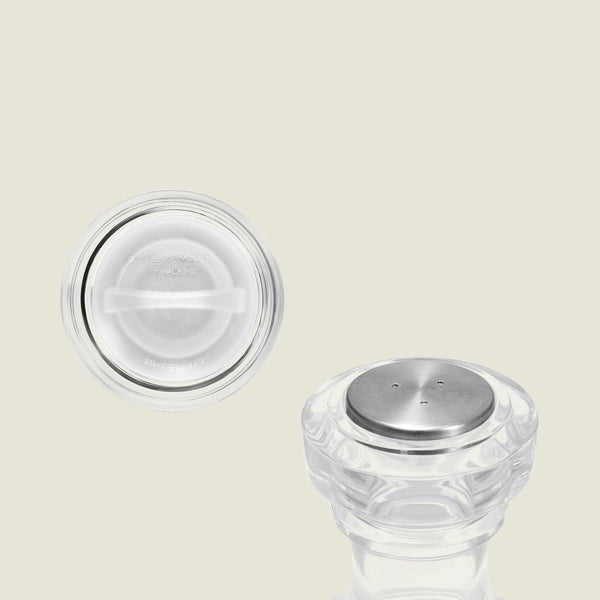 Two clear, round Cole & Mason Acrylic Salt Shaker & Pepper Mill Set (104 mm) pieces with metal tops are displayed on a light background; one stands upright while the other reveals its flat underside with embossed text. Ideal for pairing with your favorite adjustable grinder, this elegant set adds a classic touch to any table setting.