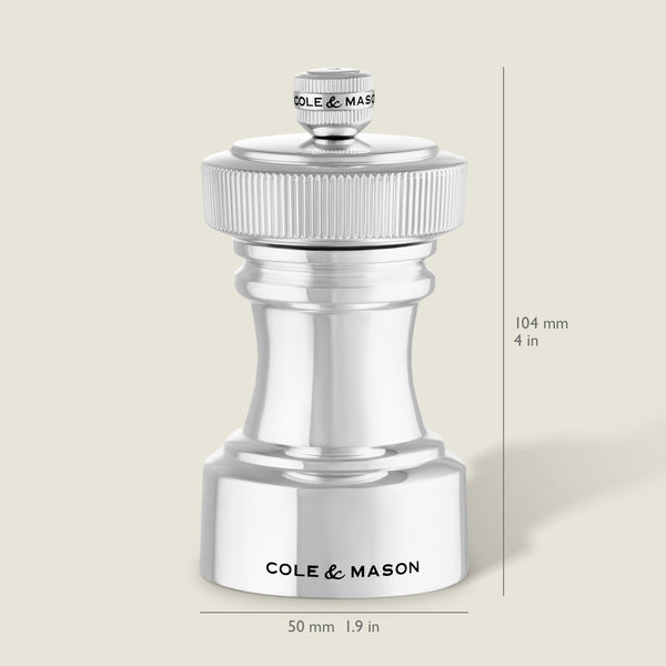 The Cole & Mason Hoxton Silver Plated Salt & Pepper Mill Set features elegant mills with ridged tops, engraved branding, and dimensions of 104 mm tall by 50 mm wide—ideal for stylish dining or sophisticated kitchen décor.