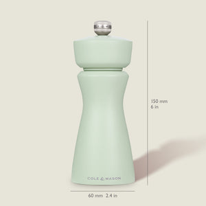 The Cole & Mason Kenton Sage Salt & Pepper Mill stands upright, displaying a pale green hue and durable ceramic mechanism. Size: 150 mm (6 in) tall, 60 mm (2.4 in) wide at the base. Background is off-white.