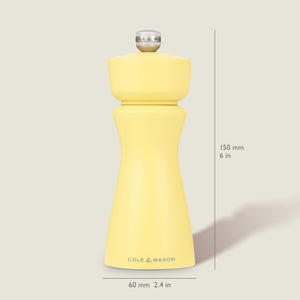 The Cole & Mason Kenton Salt & Pepper Mill in Turmeric Yellow stands upright on a light background, measuring 150 mm tall and 60 mm wide, featuring a silver top knob, ceramic mechanism, and the brand name on its base.