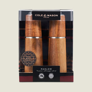 The Cole & Mason UK Marlow Natural Acacia Salt & Pepper Mills boxed set features a clear window showcasing the mills’ wood finish and branding, plus an adjustable grinder for precise seasoning.