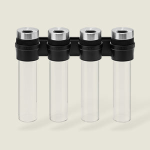 The Cole & Mason Shadwell Slim-Mount Spice Storage features four clear airtight glass containers with silver lids in a vertical black wall rack—ideal for stylish herb and spice storage.